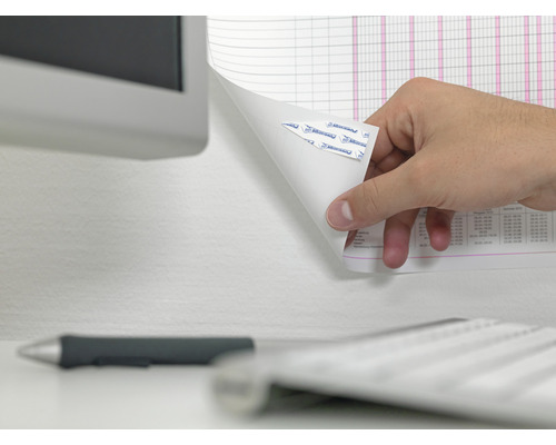 Eine Hand löst ein Blatt Papier mit Klebestreifen von einer Wand