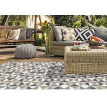 Terrasse mit Rattansitzgruppe, Schaukelbank und gemustertem Teppich