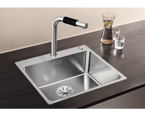 Évier en acier inoxydable avec robinet sur un plan de travail