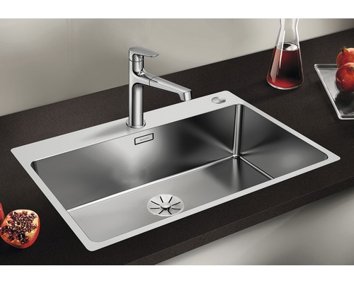 Edelstahlspüle mit Armatur auf dunkler Arbeitsfläche