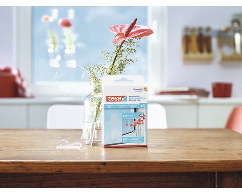 Tesa Klebestreifen Packung auf einem Holztisch mit Haken und Blume