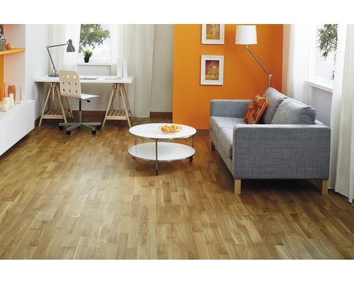 Wohnzimmer mit hellem Holzboden, Sofa, Tisch und Schreibtisch