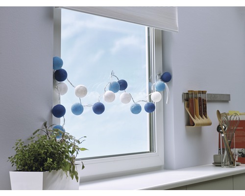 Fenêtre décorée avec guirlande lumineuse, plante et ustensiles de cuisine