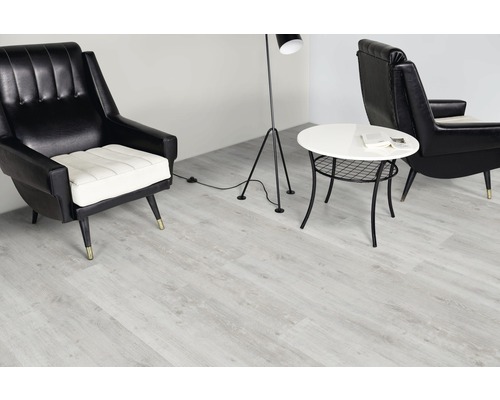Pièce à vivre avec sol vinyle clair, fauteuils, lampadaire et table d''appoint