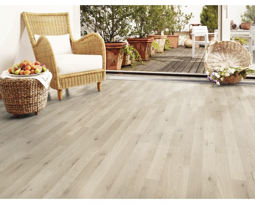 Plancher en bois clair avec fauteuil en rotin, fruits et fleurs sur la terrasse