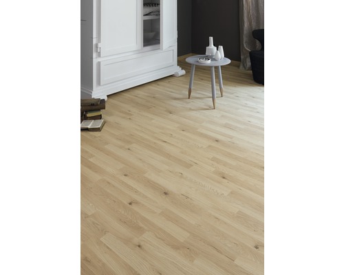 Pièce lumineuse avec sol stratifié aspect bois, armoire et petite table