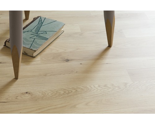 Plancher en bois clair avec pieds de table et livre