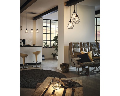 Espace de vie avec tabourets de bar, canapé en cuir, palette et plusieurs suspensions géométriques.