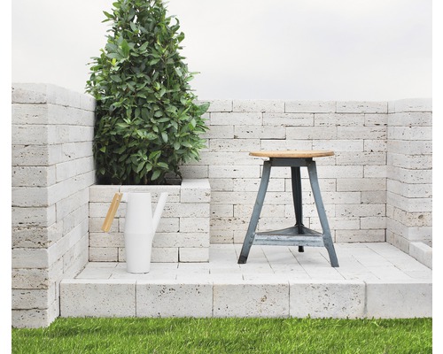 Szene mit einer Pflanze, einer Gießkanne und einem Hocker auf einer Steinplattform