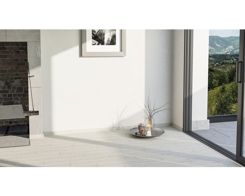 Heller Raum mit Steinboden, Kamin, Dekoration und Blick nach draußen