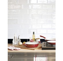 Küchenszene mit Kochgeschirr, Zutaten und weißen Fliesen