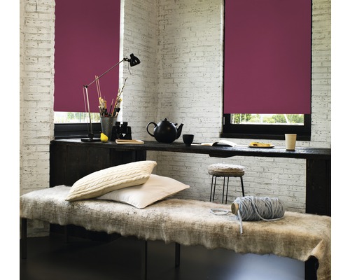 Wohnraum mit zwei Fenstern und bordeauxroten Rollos, Schreibtisch und Sitzbank