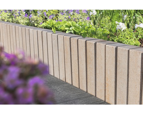 Bordure de parterre en béton avec rainures verticales dans le jardin