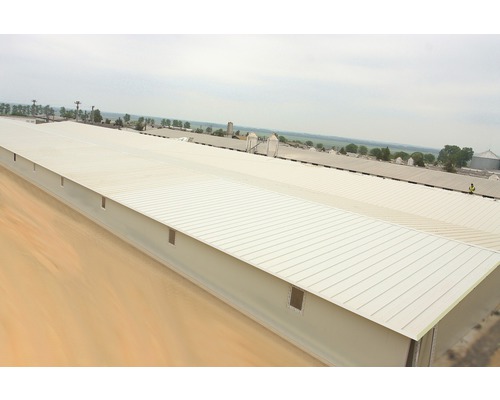 Vue d''un long bâtiment de stockage bas avec un toit en métal