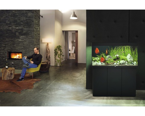 Salon avec aquarium, cheminée et homme lisant