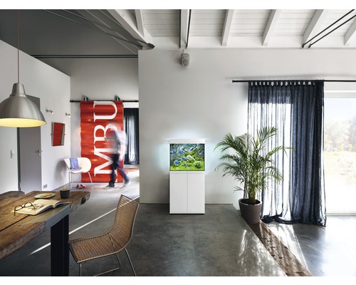 Wohnzimmer mit Aquarium auf Unterschrank, Tisch und Stühlen.