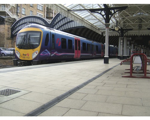 Un train se trouve sur le quai sous un toit de quai.