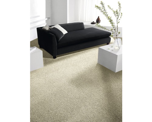 Heller Teppichboden in einem Wohnzimmer mit schwarzem Sofa und weißen Beistelltischen.