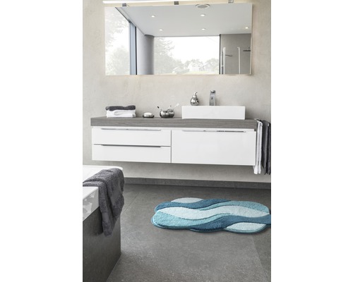 Salle de bain avec lavabo, miroir et tapis de bain bleu