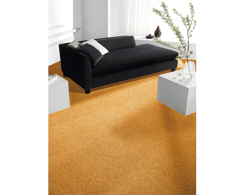 Wohnzimmer mit goldfarbenem Teppichboden, Sofa und Beistelltischen.