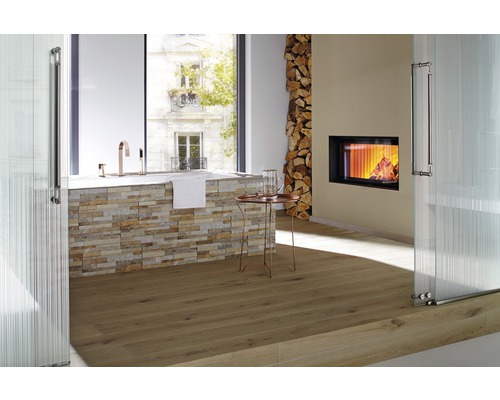 Salle de bains avec baignoire, cheminée, pile de bois et parquet