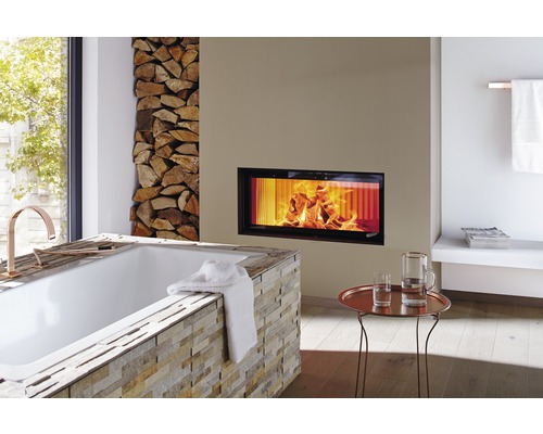 Salle de bains avec baignoire, cheminée et pile de bois