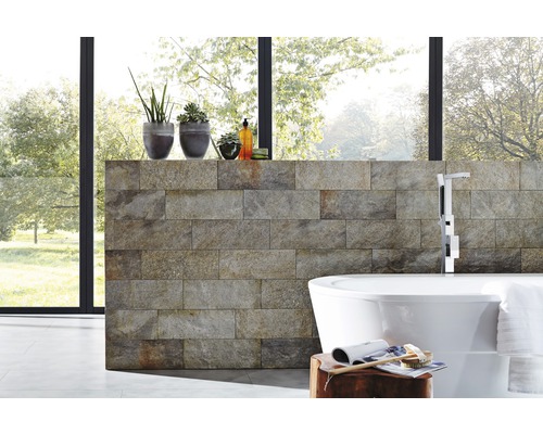 Salle de bains moderne avec mur en pierre naturelle, baignoire îlot et plantes d''intérieur