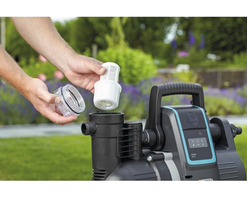 Eine Person setzt einen Filter in eine Gartenpumpe ein.