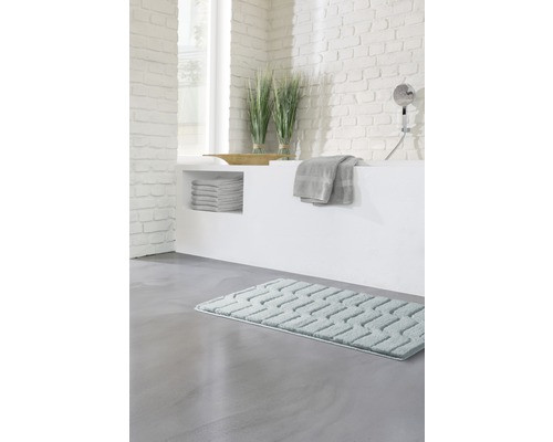 Salle de bains avec baignoire, serviettes, décoration et tapis de bain