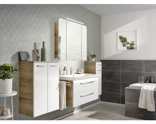 Salle de bain lumineuse avec lavabo, armoire de toilette et espace de rangement