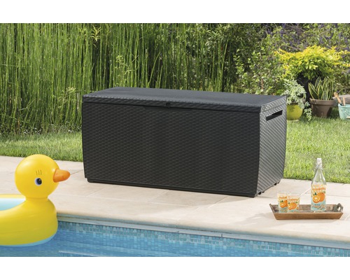 Gartenszene mit schwarzer Aufbewahrungsbox im Rattan-Look neben einem Pool