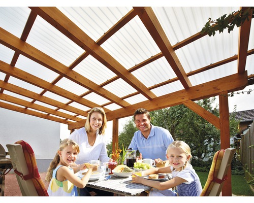 Familie beim Essen unter einer Holzpergola mit transparentem Dach