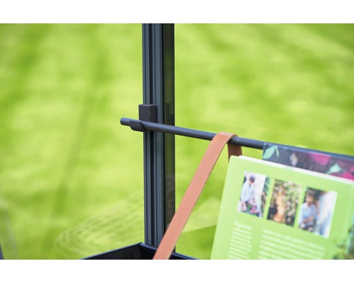 Detailansicht eines Metallregals mit Buch und Lederriemen