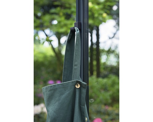 Grüne Gartenschürze hängt an einer Halterung