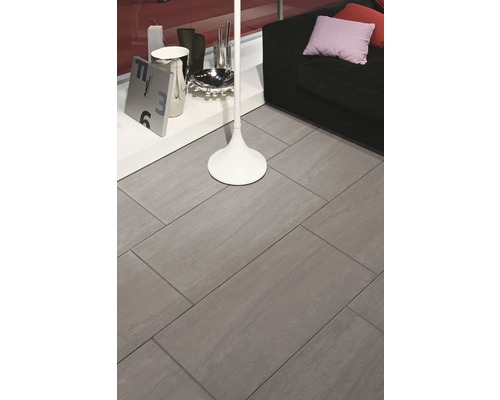 Carrelage de sol gris dans un salon avec canapé et décoration.