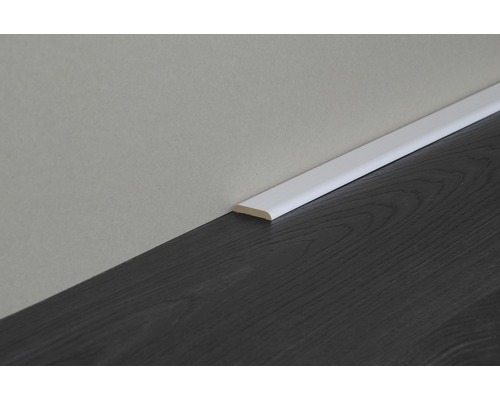 Plinthe blanche sur parquet foncé contre un mur