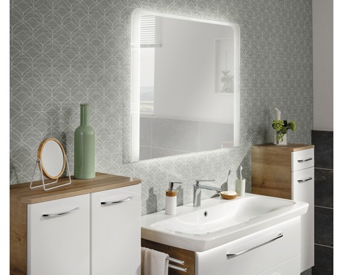 Badezimmer mit Waschtisch, beleuchtetem Spiegel und Unterschrank