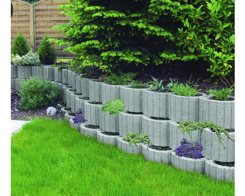 Jardin en terrasses avec pierres à plantes grises et plantes vertes