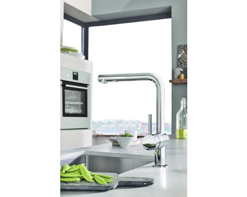 Scène de cuisine avec évier, robinet et légumes sur une planche à découper