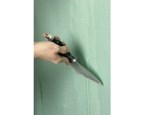 Main avec spatule lors du jointoiement d''une plaque de plâtre