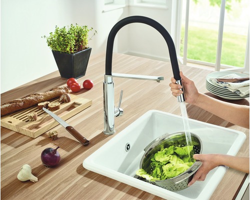 Scène de cuisine avec évier, robinet avec bec flexible et aliments