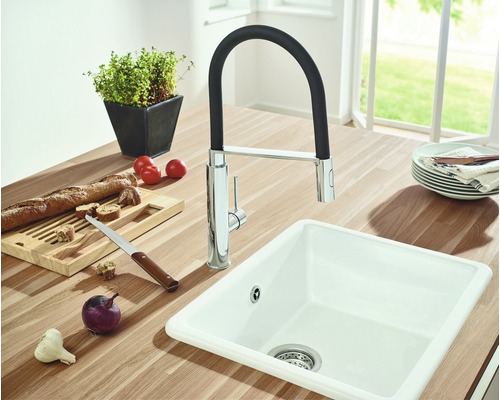 Évier de cuisine avec robinet, entouré d''aliments sur un plan de travail.