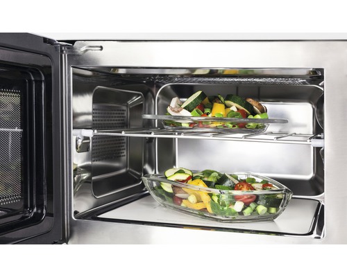 Intérieur d''un four à micro-ondes avec deux plats en verre contenant des légumes