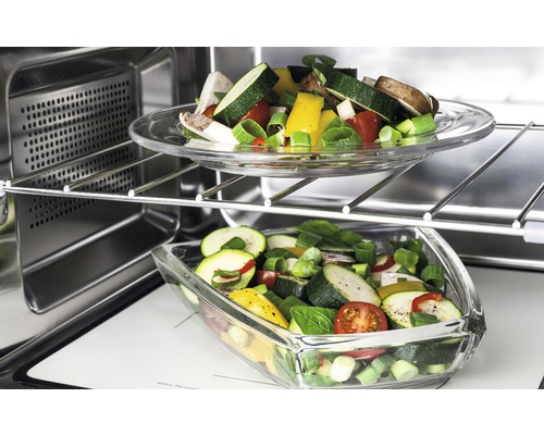 Deux récipients en verre contenant des légumes coupés dans un four.