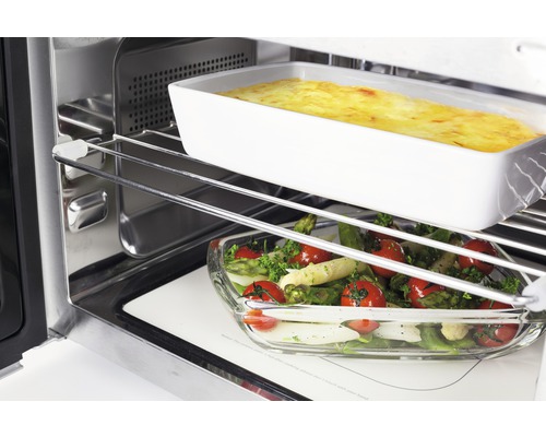 Vue intérieure d''un four avec des aliments dans un plat à gratin et un plat en verre