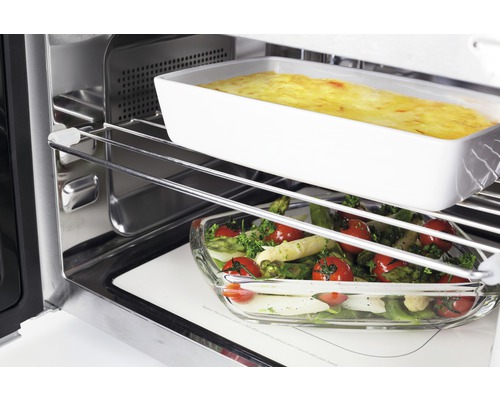 Vue intérieure d''un four avec des plats dans des plats à gratin sur des grilles