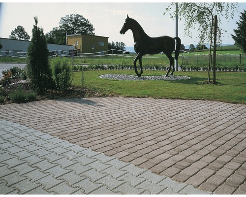 Gepflasterte Einfahrt mit Rasenfläche und Pferde-Skulptur