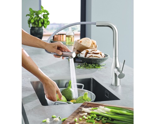 Scène de cuisine avec robinet d''évier et personne lavant des légumes