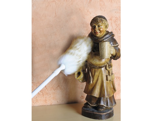 Plumeau dépoussiérant une figurine de moine en bois