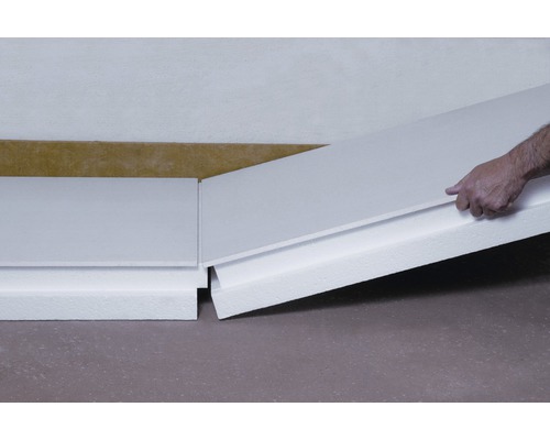 La scène montre l''installation de plinthes avec isolation thermique.